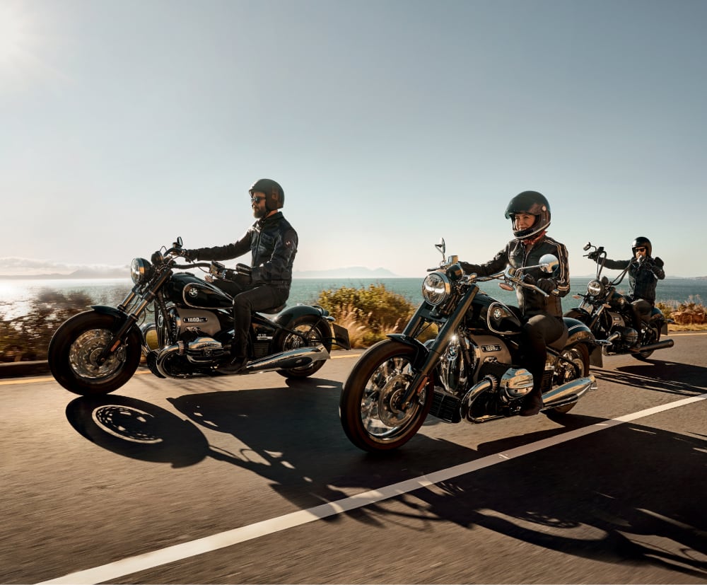 Motorcyclists riding outside scenic ocean landscape